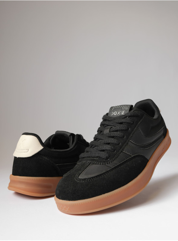 Zapatilla negra de mujer con suela gum, ideal para complementar outfits sin sobrecargar.