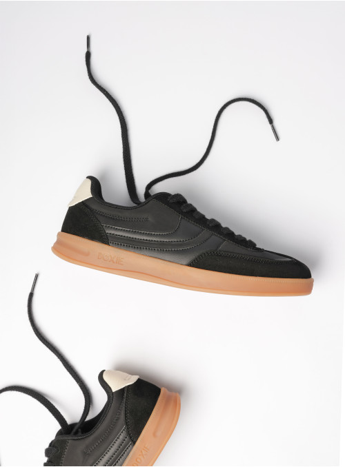 Zapatilla negra de mujer con suela gum, ideal para complementar outfits sin sobrecargar.