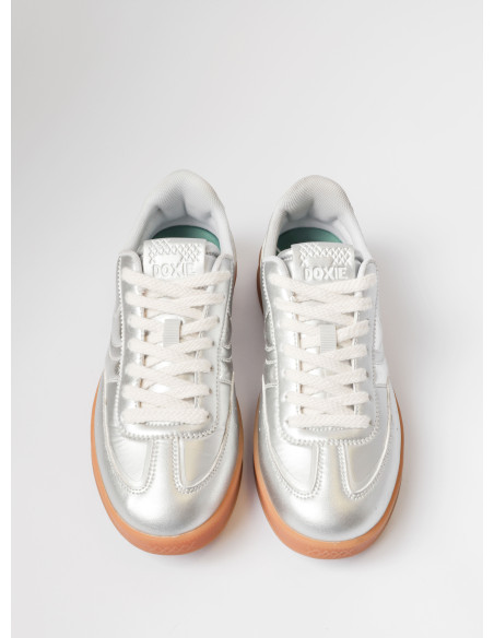 Zapatilla brillante en plata, mezcla de materiales que aporta originalidad y comodidad a looks casuales.