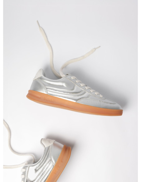 Zapatilla de mujer en plata, combina un diseño clásico con un acabado brillante para destacar en cualquier ocasión.