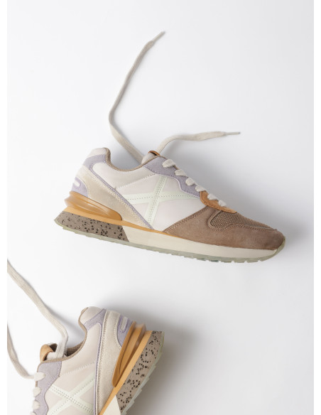 Zapatilla de mujer en color beige, con diseño que respira, adecuada para un uso prolongado y cómodo en la ciudad.