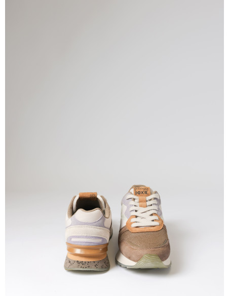 Zapatilla femenina beige, con diseño suave y equilibrado, perfecta para un look casual y activo.