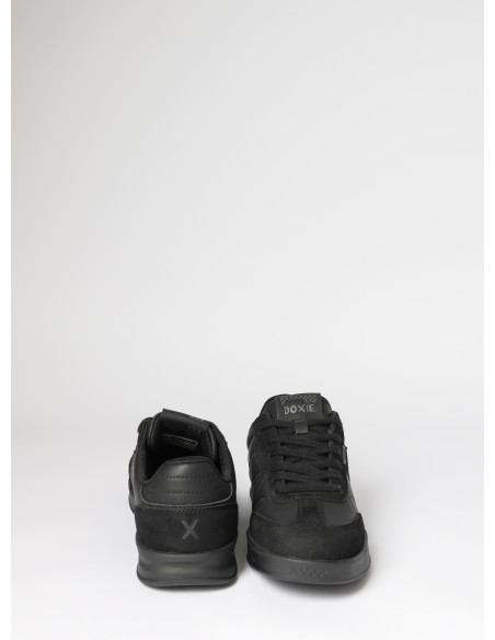 Zapatilla negra unisex con silueta baja, ideal para actividades en la ciudad.