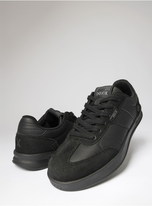 Zapatilla urbana unisex de cuero sintético negro con diseño total black y texturas oscuras.