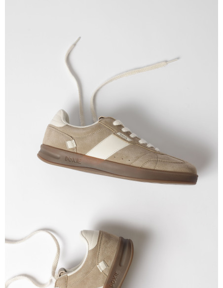 Vista del talón de la zapatilla unisex beige, resaltando su diseño cómodo y funcional.