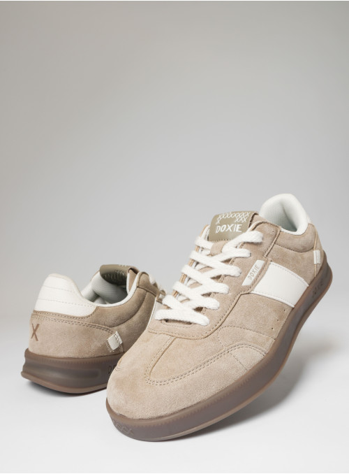 Vista lateral de zapatilla beige, mostrando su textura auténtica y diseño sencillo.