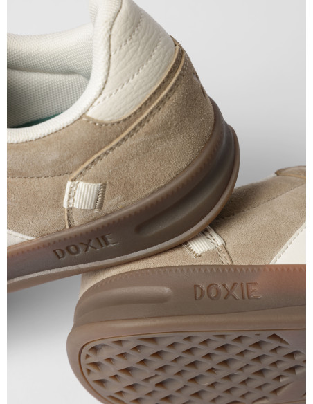 Zapatilla unisex beige de estilo urbano, confeccionada en cuero y sintético, ideal para caminatas relajadas.