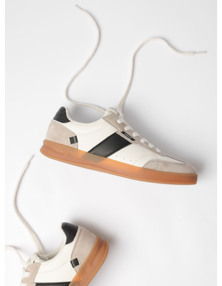 Zapatilla de cuero sintético blanca con diseño minimalista y cómodo para el día a día.