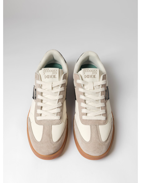 Zapatilla blanca de estilo urbano con detalles contrastantes en cuero.