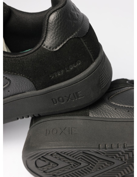 Vista trasera de zapatilla negra unisex, destacando su diseño elegante y funcionalidad para el uso diario.