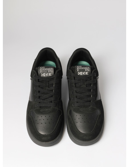 Vista lateral de zapatilla negra unisex, diseño robusto y moderno, perfecta para la ciudad.