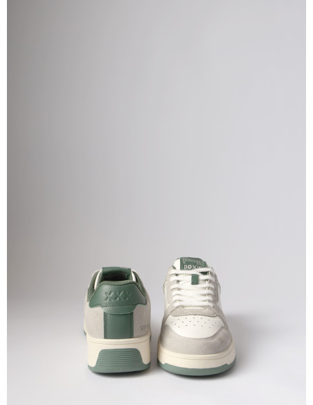 Zapatilla sintética unisex en verde orgánico, combinando confort y estética moderna para el asfalto.