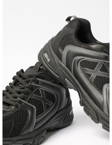 Zapatilla negra unisex con detalles en cuero, perfecta para un estilo urbano y dinámico.