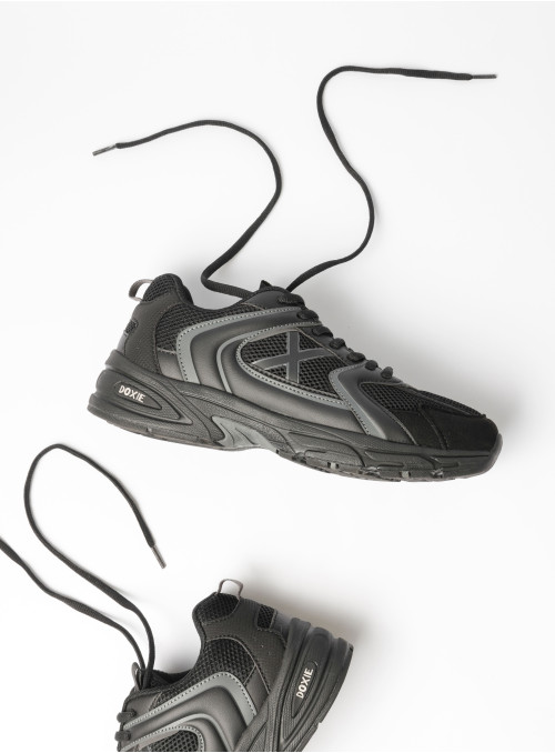 Perspectiva superior de zapatilla negra con material textil, combinando confort y soporte.