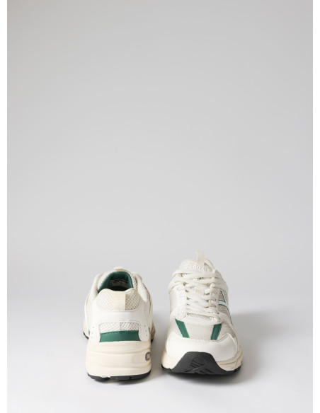 Zapatilla unisex blanca de cuero y textil, estilo urbano, ideal para actividades en la ciudad.