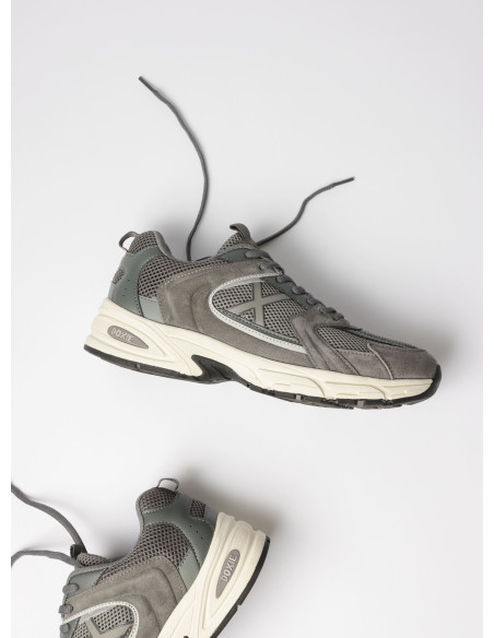 Zapatilla gris unisex con acentos de color, diseñada para moverse con la ciudad.