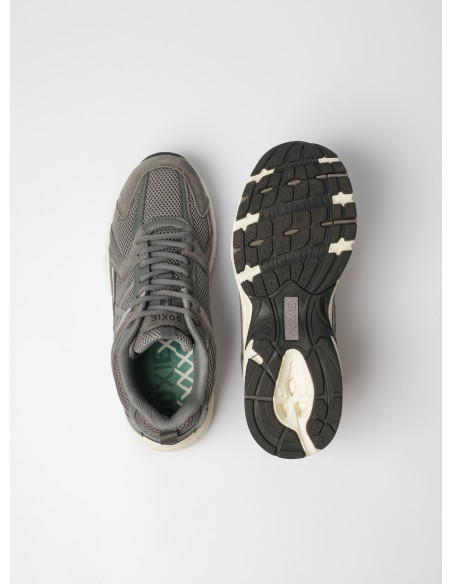 Perspectiva de zapatilla gris unisex, fusionando comodidad y estilo para un uso diario.