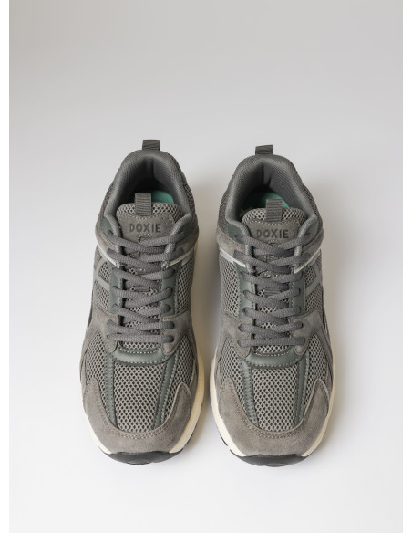 Zapatilla gris unisex con diseño sólido y capas visibles, adecuada para un estilo urbano.