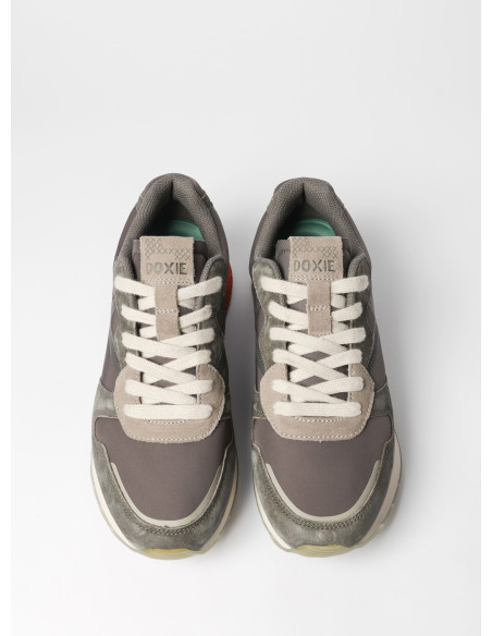 Vista lateral de la zapatilla gris unisex, resaltando su diseño equilibrado y moderno.