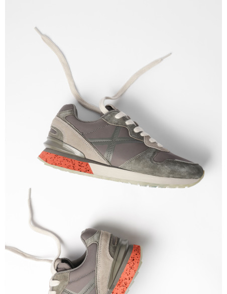 Perspectiva que muestra la textura del cuero en la zapatilla gris unisex, perfecta para el estilo urbano.