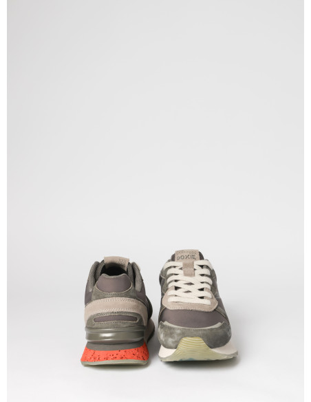 Zapatilla gris unisex con detalles en textil, diseñada para un movimiento cómodo y seguro en la ciudad.