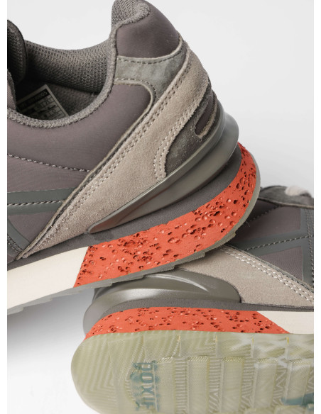 Zapatilla urbana unisex en gris, fabricada en cuero y textil, ideal para actividades diarias.